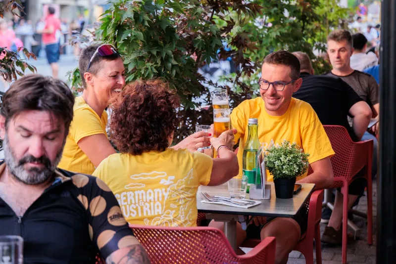 Riders sharing drinks at a café table in Innsbruck