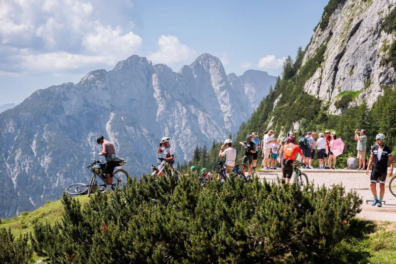 Riders on the Vršič road with the peaks of the Julian Alps behind them